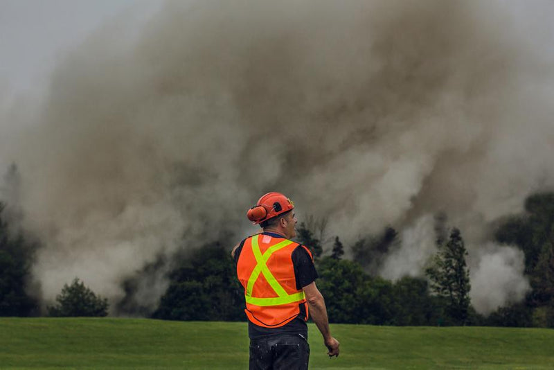 Man in safety vest in front of smoke